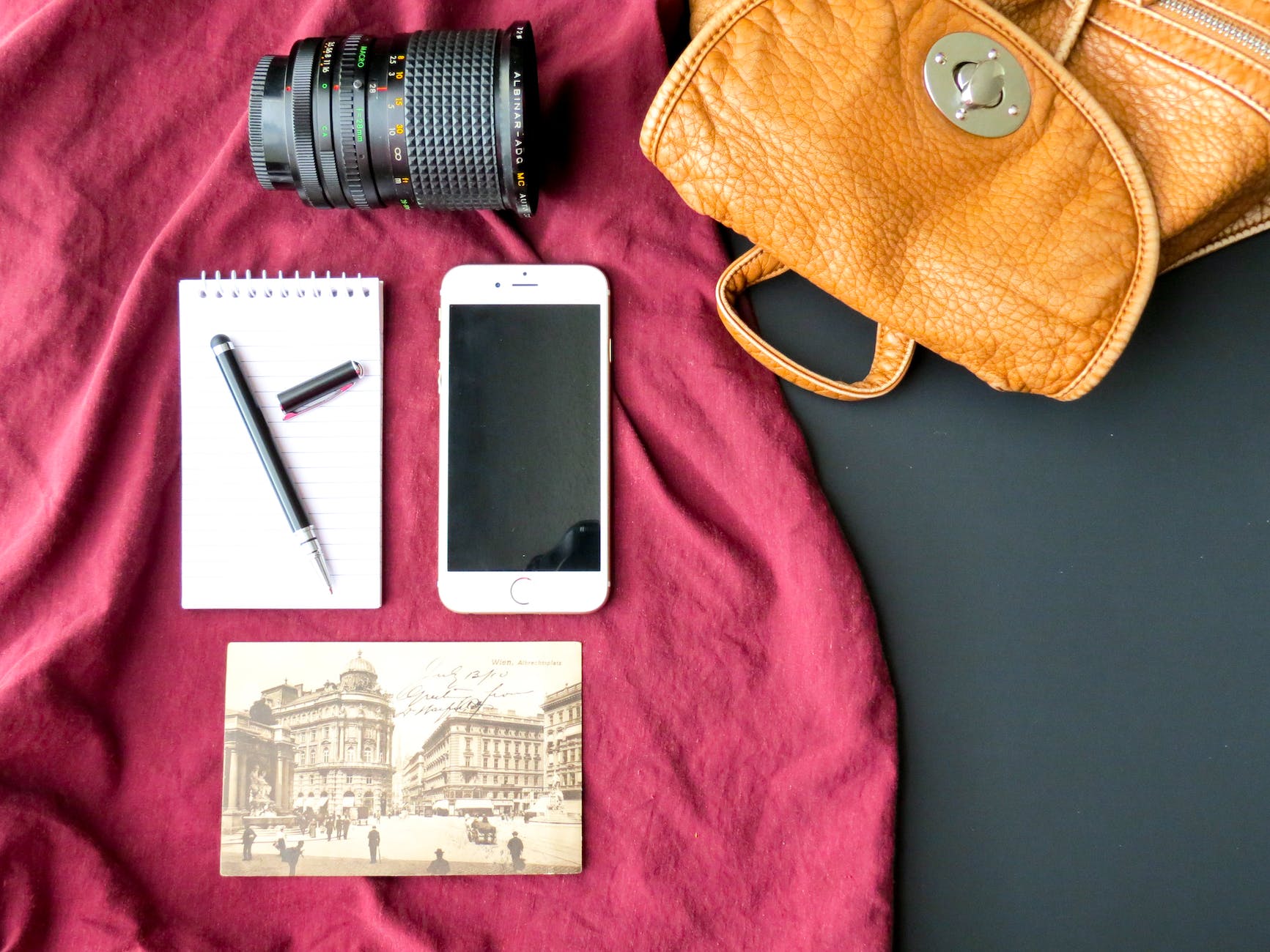 flat lay photography of iphone notebook and dslr lens